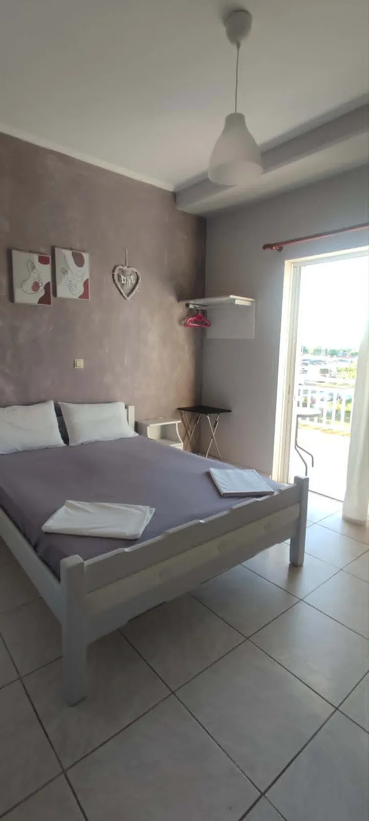 Double room with mauve feature wall and balcony