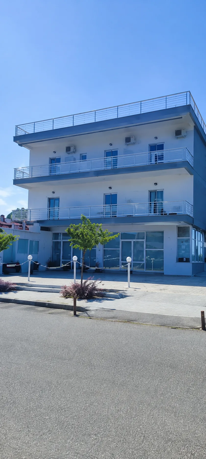 The Port Hotel building with white balconies in Paralia Katerinis