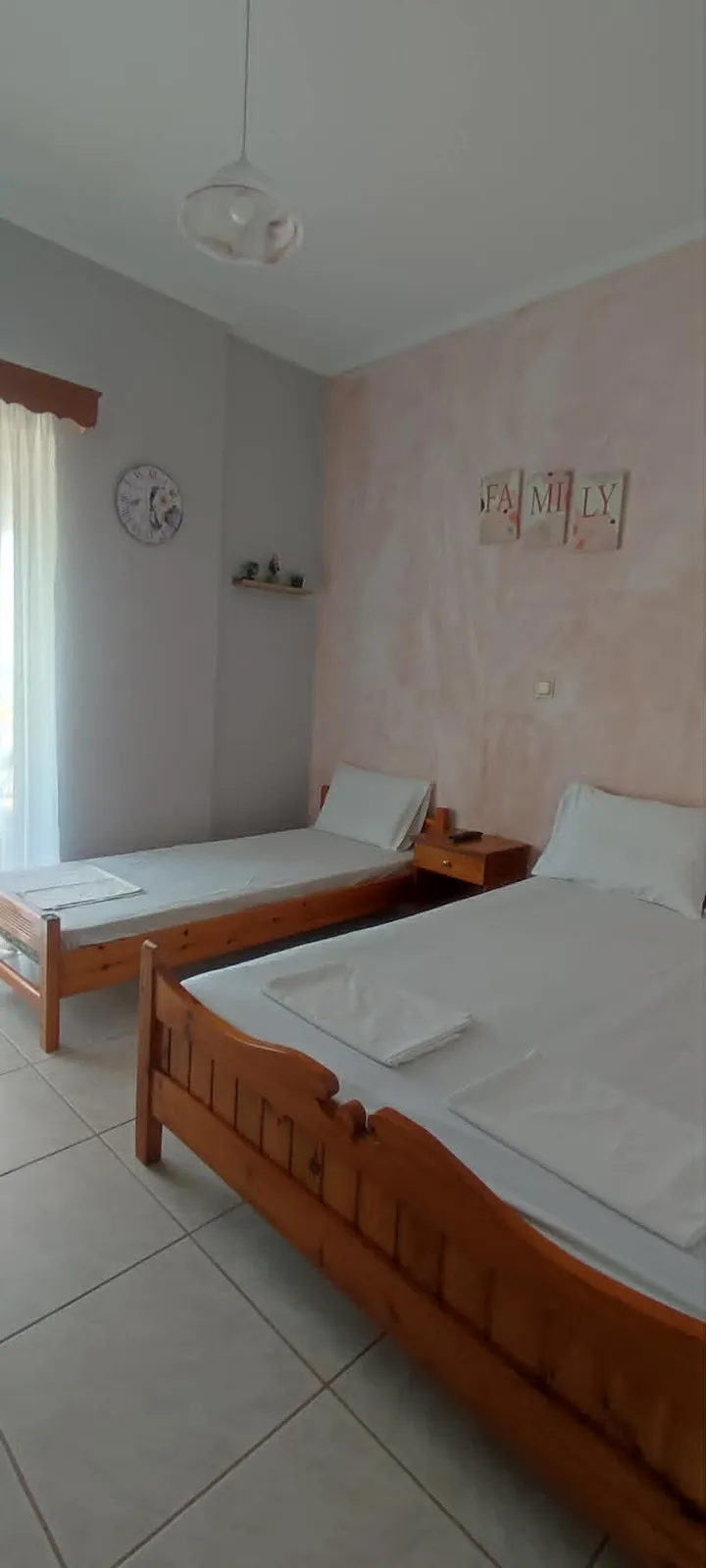 Family triple room with two beds and pastel walls